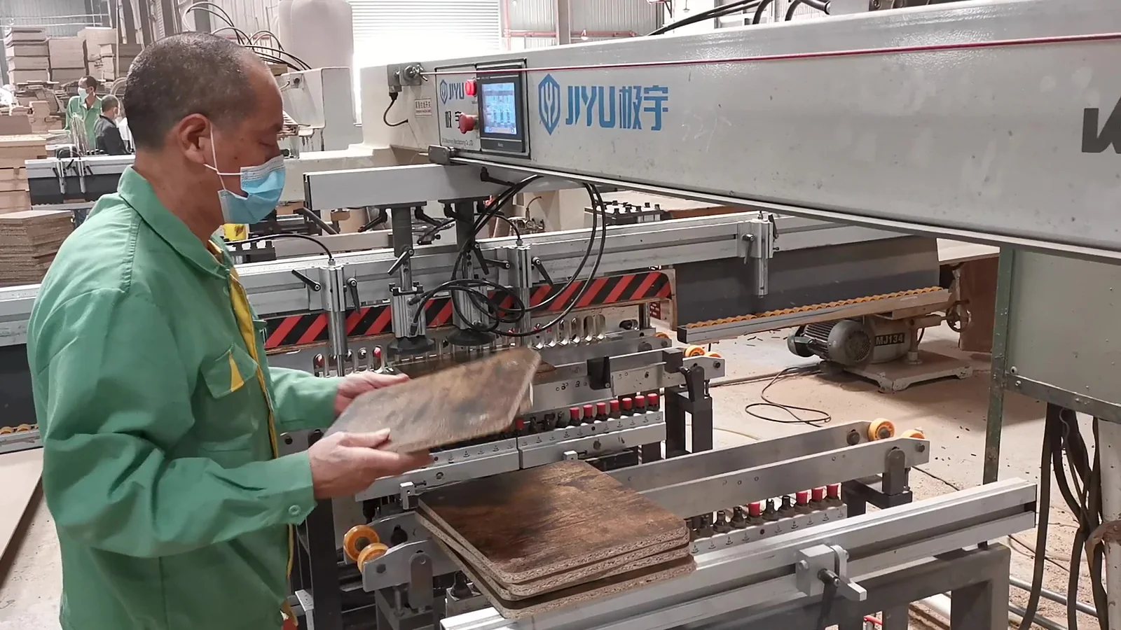 Worker visually checking a furniture panel before machine processing