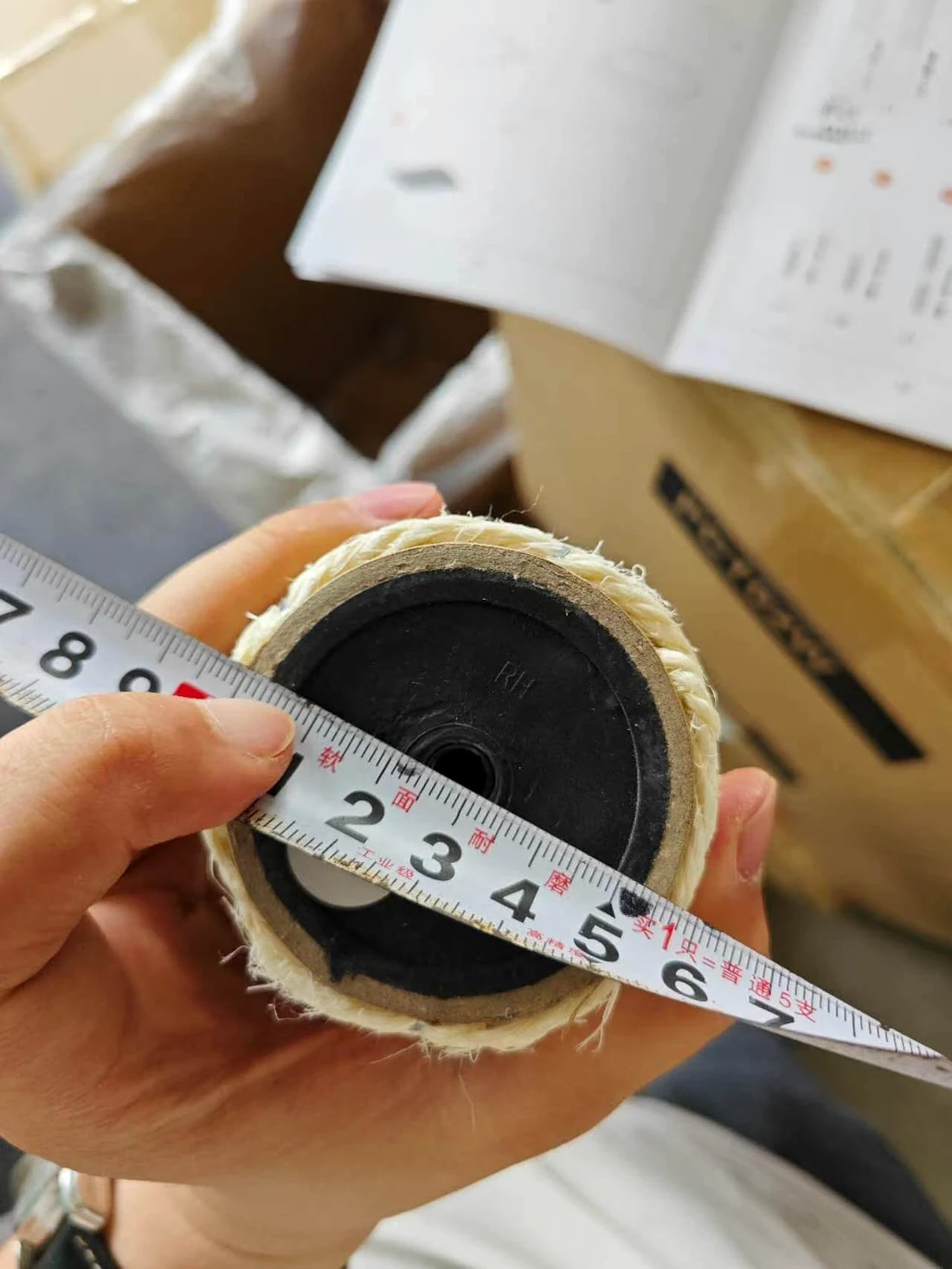 Tape measure checking the diameter of a wrapped cat tree post