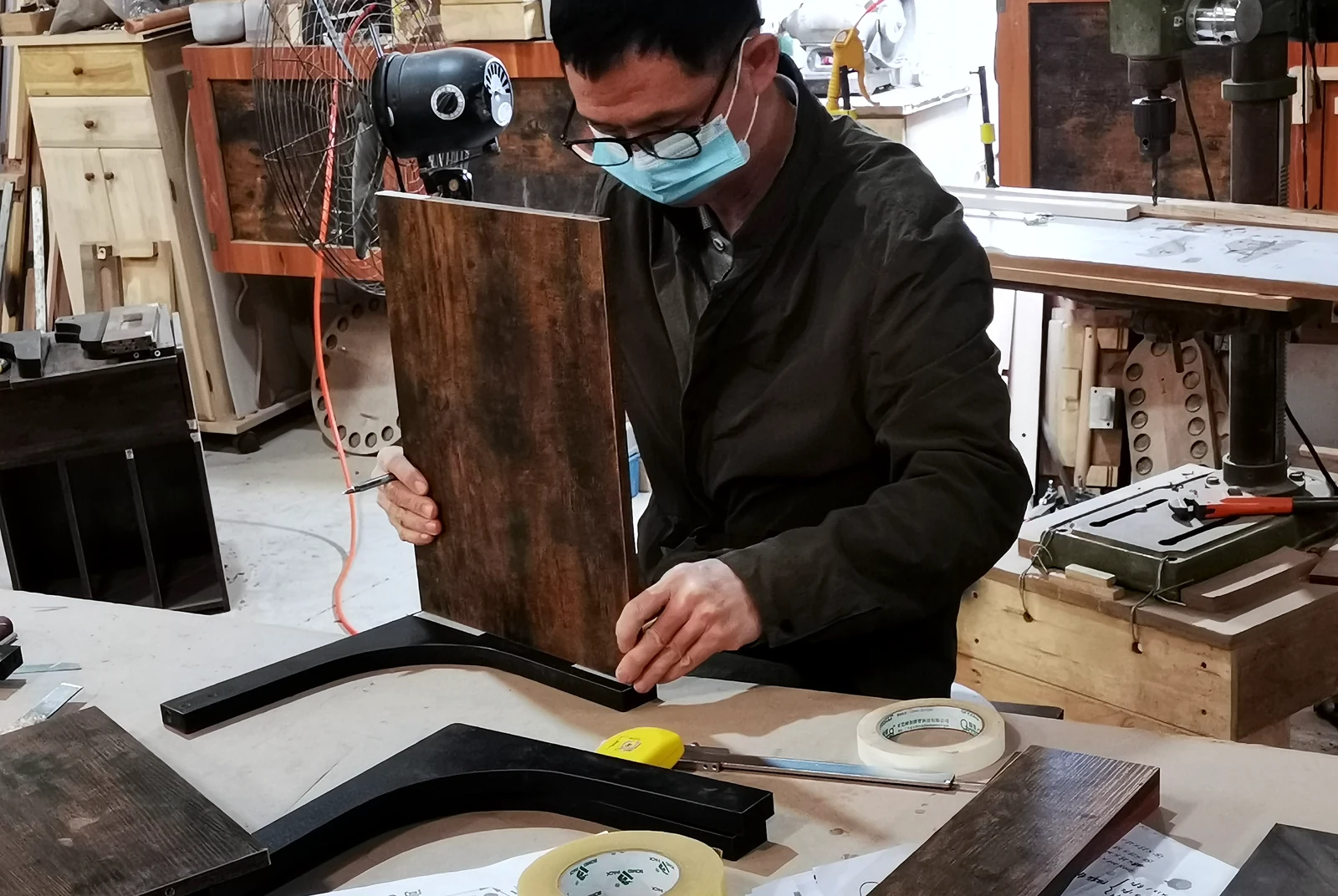 Worker checking the fit between a furniture panel and metal frame
