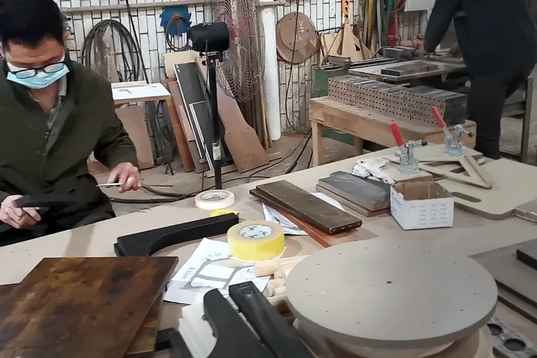 Worker marking and checking a furniture sample at a development worktable