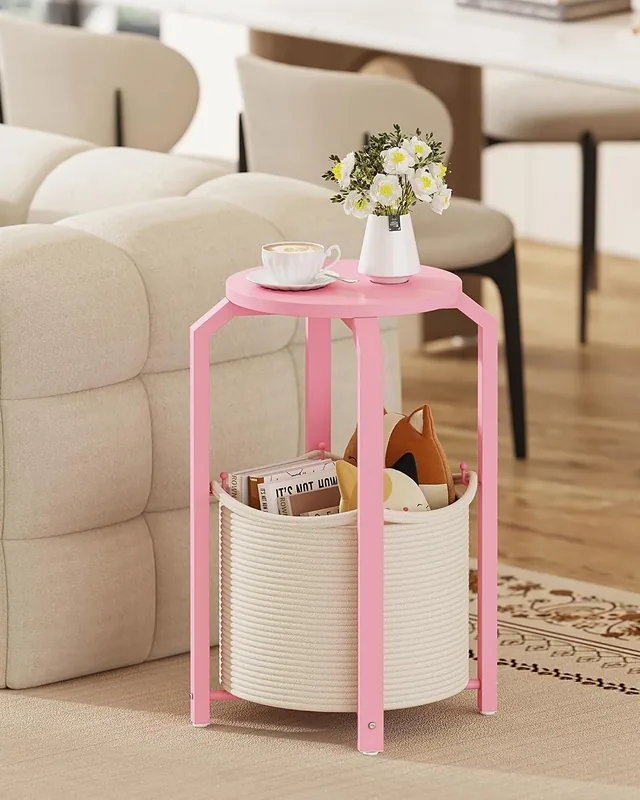 Pink round side table with a woven lower basket beside a sofa
