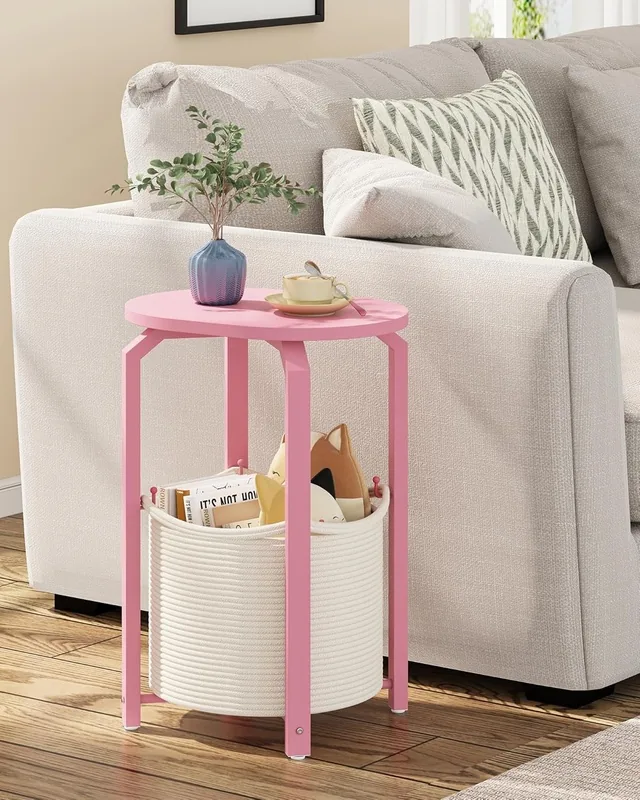 Pink oval side table with a woven storage basket beside a sofa